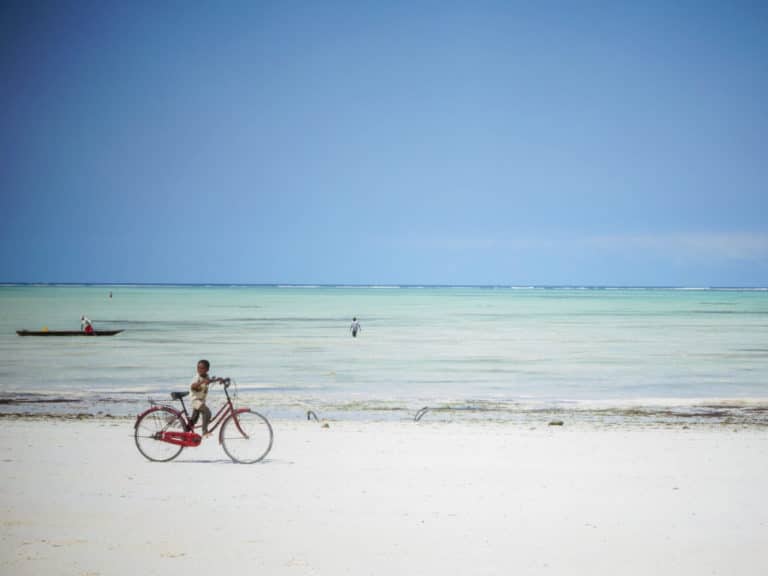 Junge mit Fahrrad am Strand