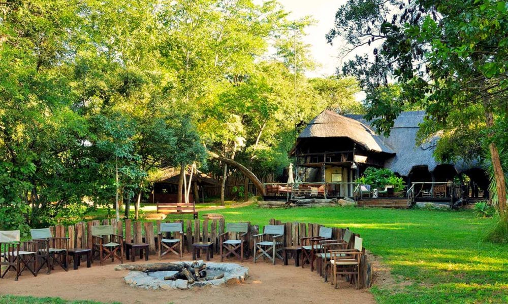 Lodge mit Lagerfeuer im Garten und Stühlen