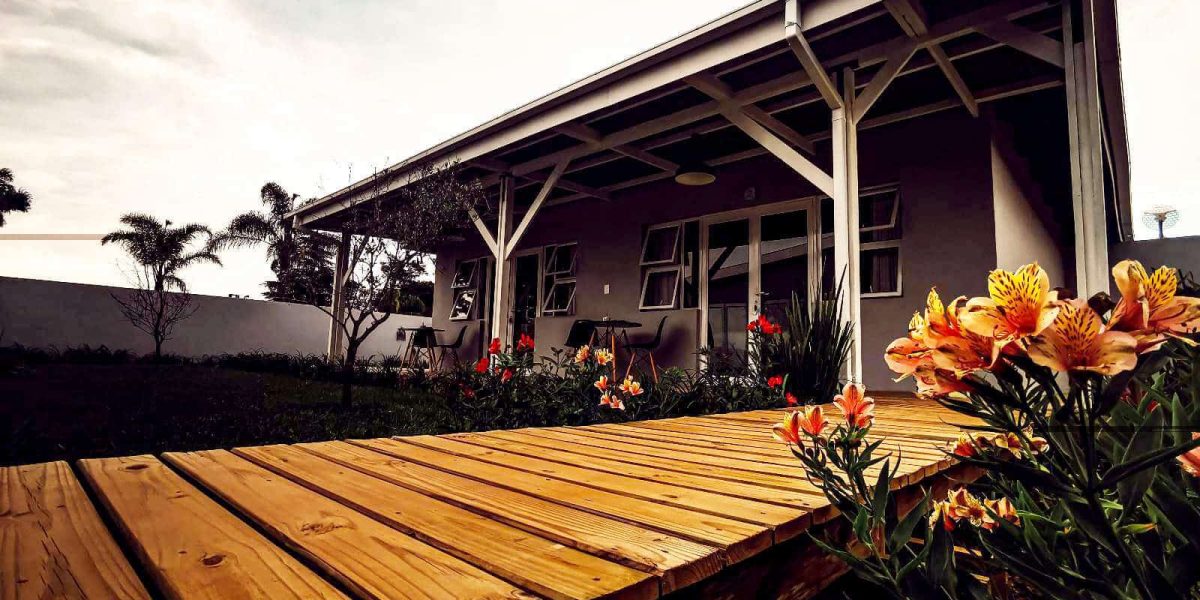Holzdeck mit Blumen und Unterkunft